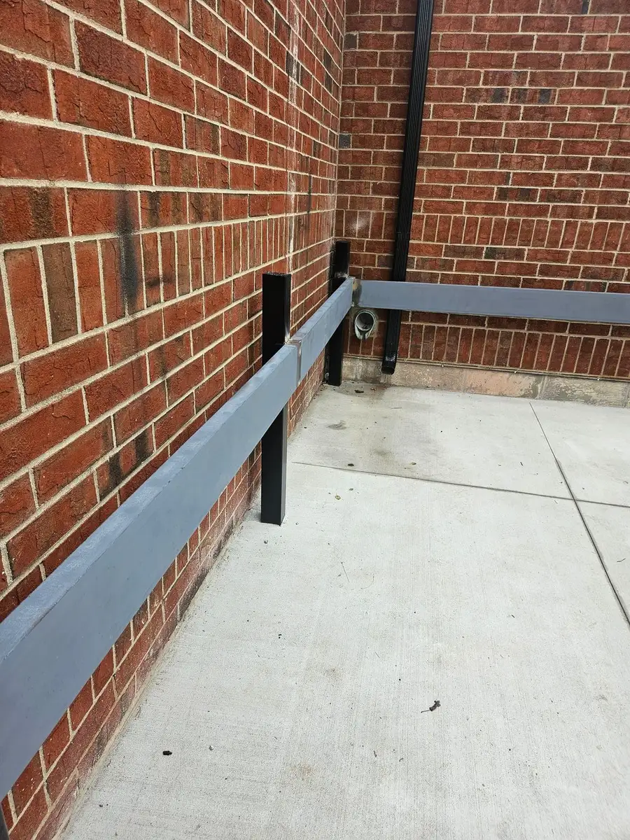 Custom steel guardrail installed along a brick building
